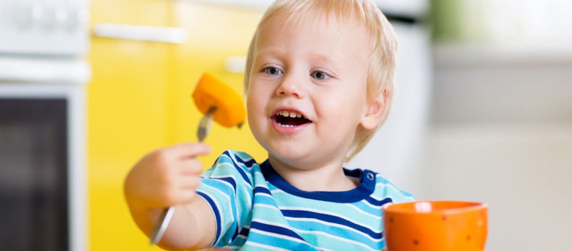 47672341 - cute child little boy eating healthy food in kitchen